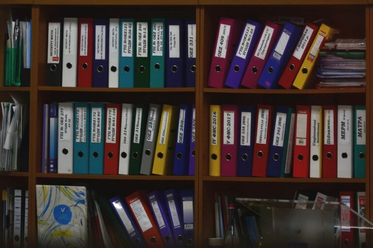 Fileiras de pastas de arquivo coloridas organizadas em estantes