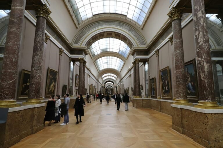 Visitantes percorrendo a grande galeria de um museu de arte