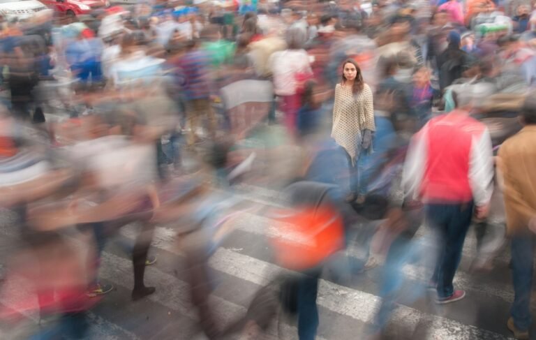 Multidão de pessoas caminhando por rua movimentada da cidade