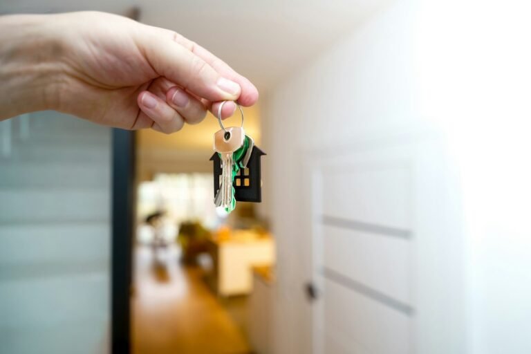 Corretor de imoveis entregando as chaves de um novo imovel na entrada da casa
