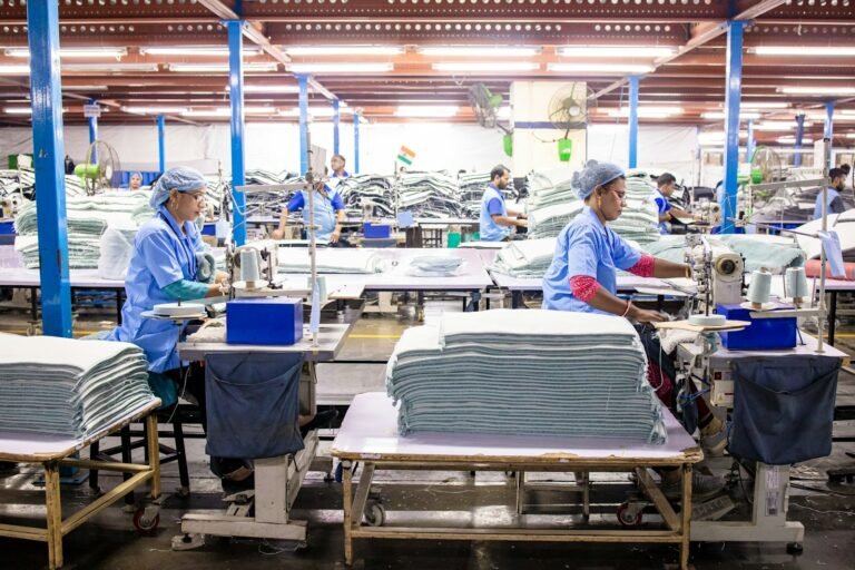 Operarios trabalhando em linha de producao de uma fabrica textil