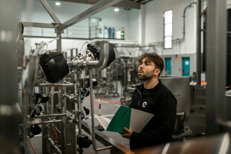 Tecnico inspecionando maquinario industrial com documentacao tecnica