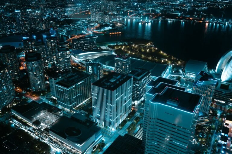 Cidade iluminada a noite com arranha-ceus e orla