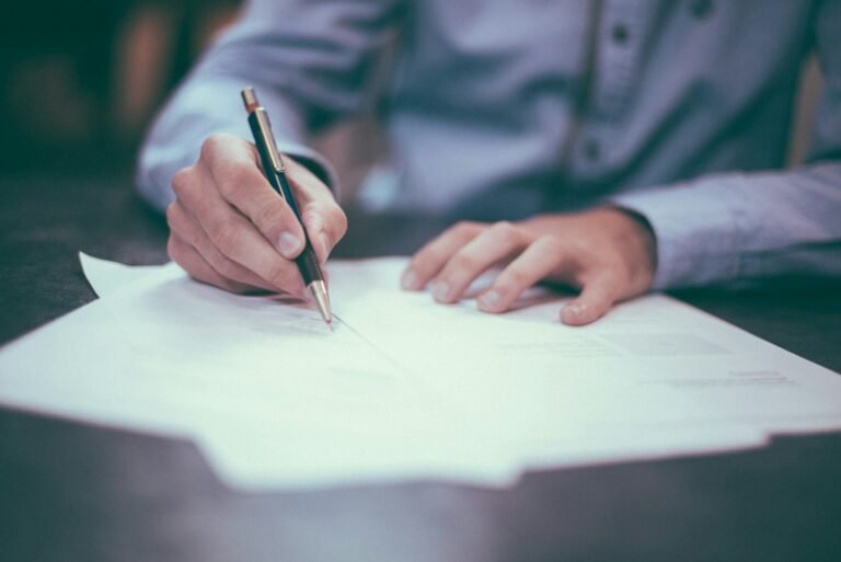 Assinatura de contrato com caneta sobre documento