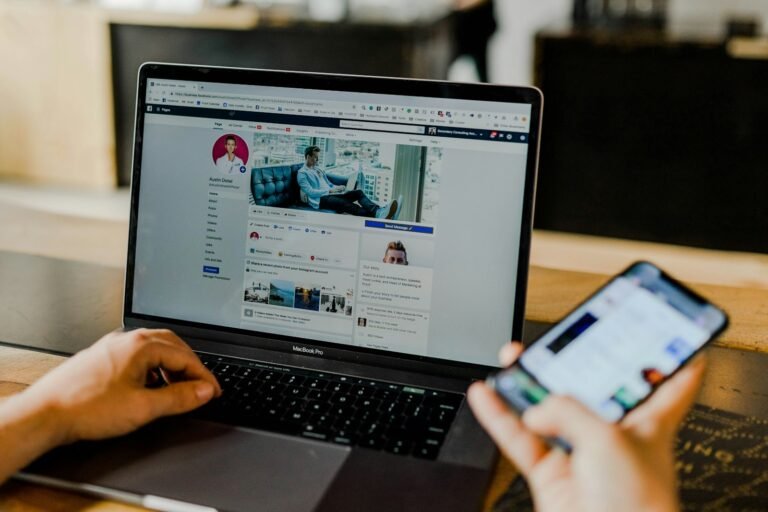 Rede social aberta em notebook e celular lado a lado