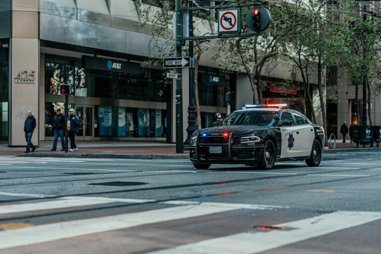 Viatura policial com giroflex em rua movimentada da cidade