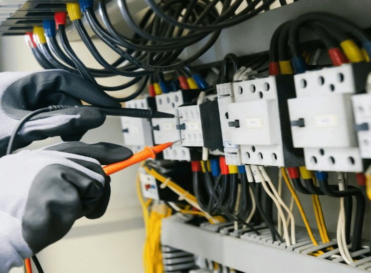 Eletrotécnico medindo um painel elétrico